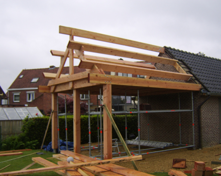 Carport in douglas hout aangebouwd aan garage. Hout dikte voorzien voor dragen zonnepanelen